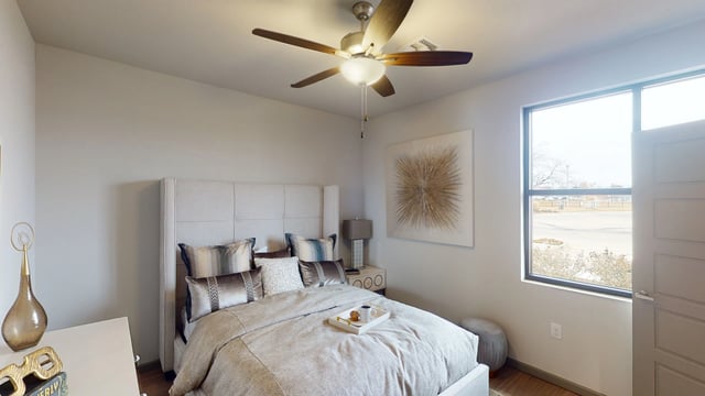 Cozy bedroom with a queen-sized bed, plush pillows, and a ceiling fan.