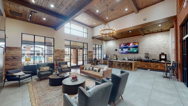 Lobby with seating areas, coffee bar, and view of pool through windows.