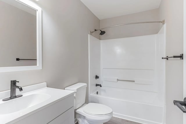Modern bathroom with a vanity, toilet, and shower/tub combo.