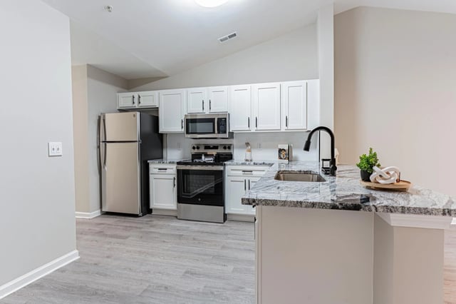 Modern kitchen with stainless steel appliances and granite countertops.