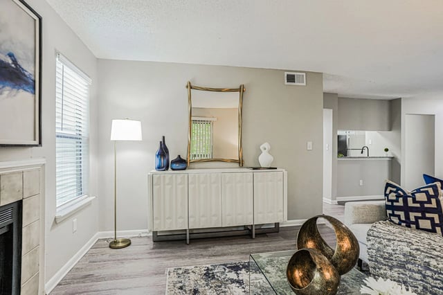 Living room with fireplace, floor lamp, console, and mirror.