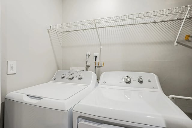 Washer and dryer units with a shelf above.