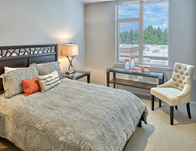 Bedroom with a large bed, nightstand, and a window with a view.