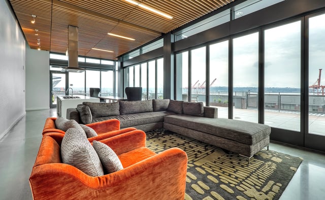 Modern living room with large sectional sofa, armchairs, and city view.