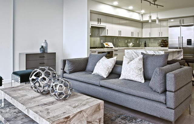 Modern living room with grey sofa and open-concept kitchen.