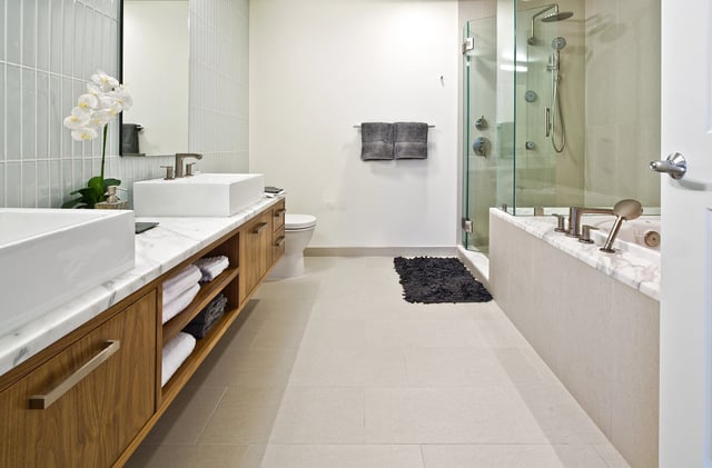 Modern bathroom with dual vanities, a soaking tub, and a glass-enclosed shower.