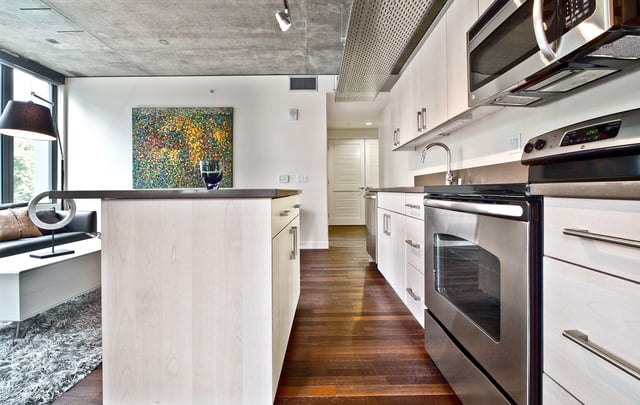 Modern apartment kitchen with stainless steel appliances and island.