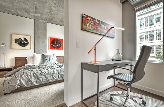 Modern bedroom and workspace with artwork.