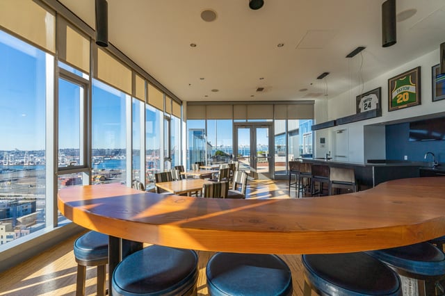 Bar area with seating and city views in a community lounge.