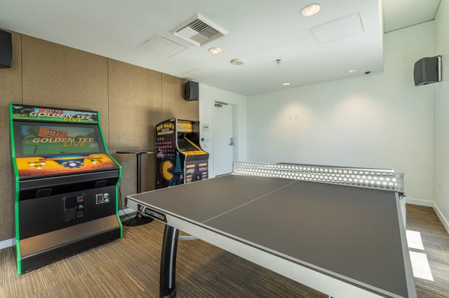 Game room with arcade games and ping pong table.