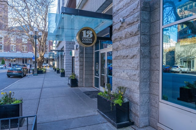 Exterior view of a building entrance with a sign for 18 COINS 24-7 DINING.