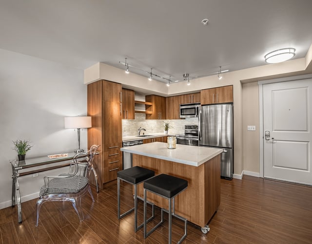 Modern kitchen with island and stainless steel appliances.