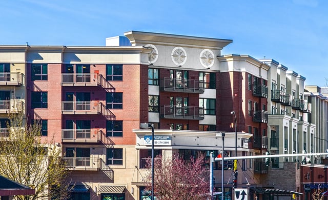 Modern apartment building exterior with brick facade and balconies.