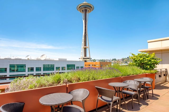Rooftop patio seating with view of the Space Needle and city skyline.