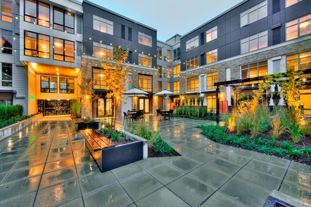 Courtyard with seating areas and plants at a modern apartment building.