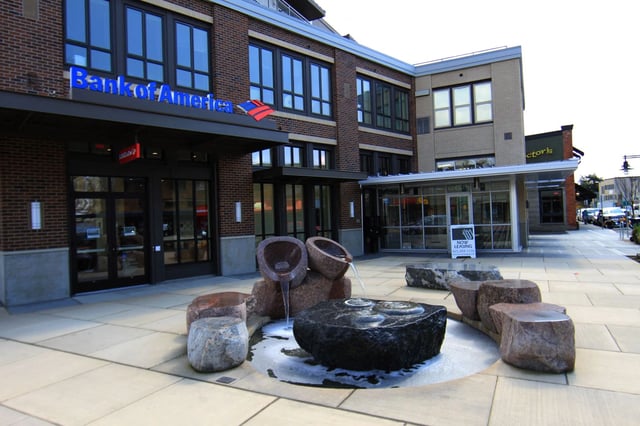 Modern brick building with Bank of America signage and a stone water feature in front.