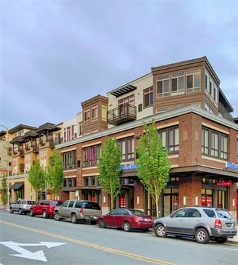 Exterior view of a modern apartment building with brick accents and balconies.