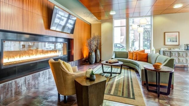 Lobby area with a modern fireplace, comfortable seating, and a coffee bar.