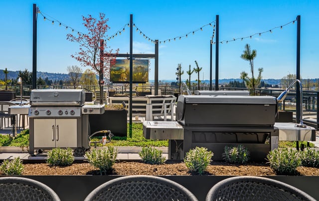 Outdoor grills and seating area on a rooftop patio.