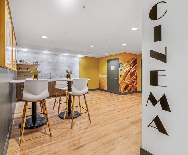 Community cinema room with bar seating and a kitchenette.