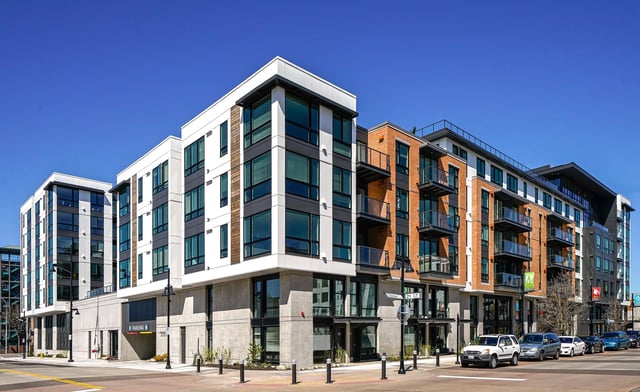 Modern apartment building exterior with mixed materials and balconies.