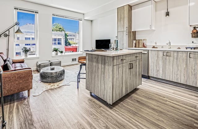 Modern living room and kitchen with large windows and island.
