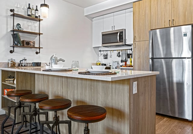 Modern kitchen with island bar seating, stainless steel appliances, and ample cabinet space.