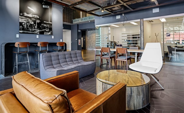 Stylish lounge area with comfortable seating, bar stools, and a large black and white photo on the wall.