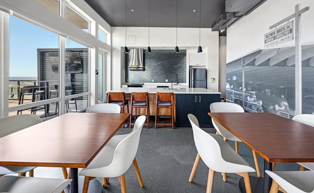 Communal kitchen and dining area with modern seating and a scenic view.