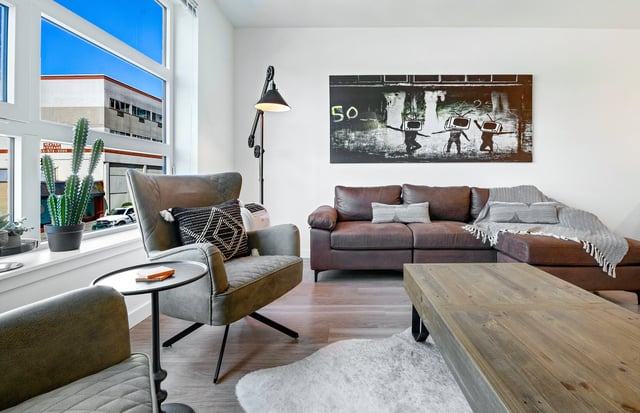 Modern living room with comfortable seating, coffee table, and large window.