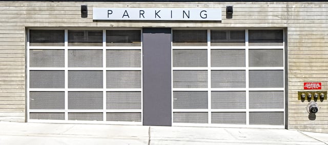 Parking garage entrance with the word PARKING above two large doors.