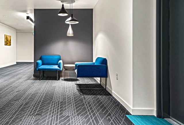 Modern hallway with blue chairs and abstract carpet