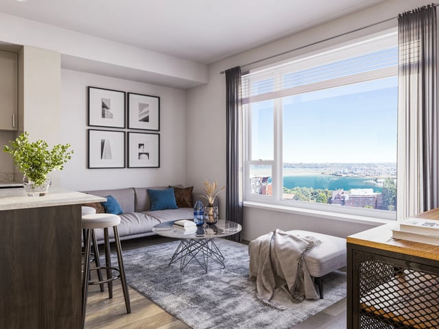 Modern living room with sofa, coffee table, and large window with city view.