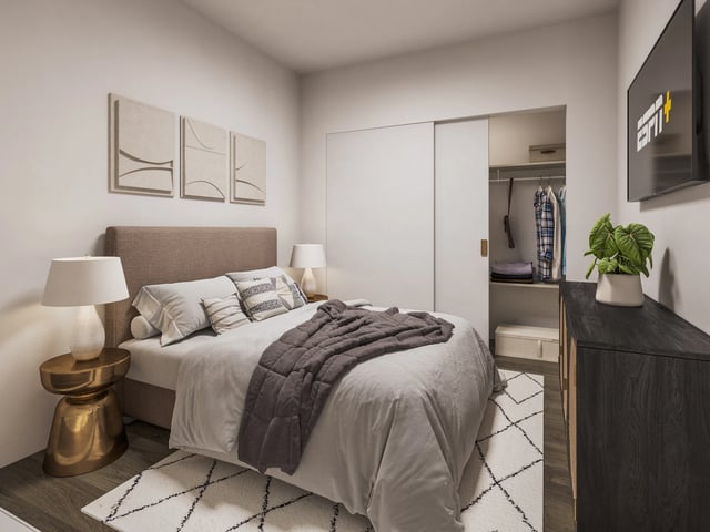 A beautifully staged bedroom with a queen-sized bed, modern decor, and a large closet.