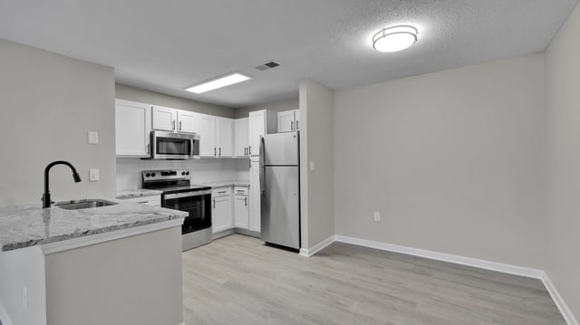Modern kitchen with granite countertops, stainless steel appliances, and ample cabinet space.