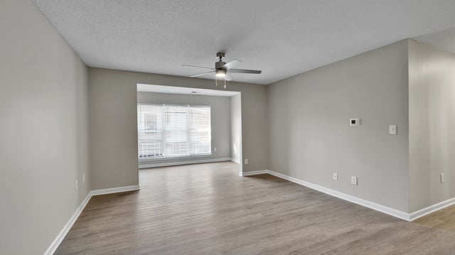Living room with wood-look flooring and a ceiling fan
