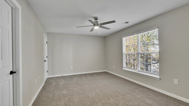 Bedroom with plush carpet and a ceiling fan