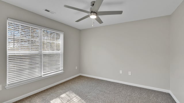Empty bedroom with a ceiling fan and blinds on the window.