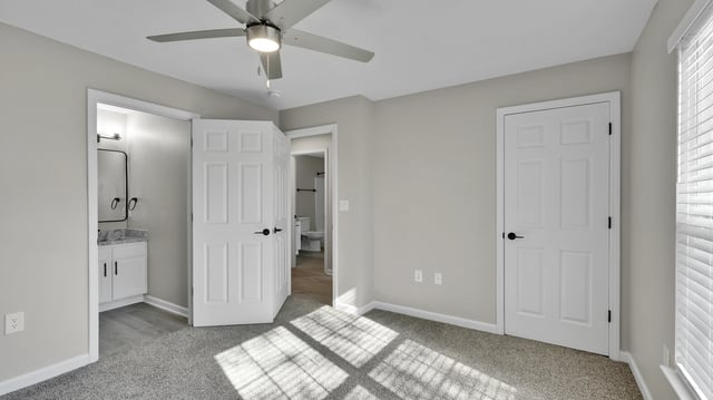Bedroom with ensuite bathroom and a ceiling fan.