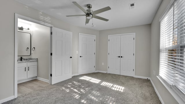 Bedroom with ceiling fan and closet doors