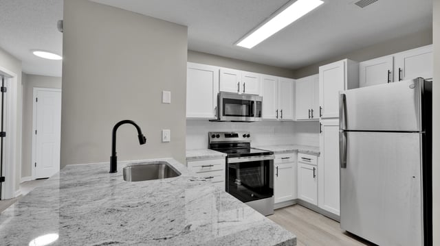 Modern kitchen with stainless steel appliances and granite countertops.