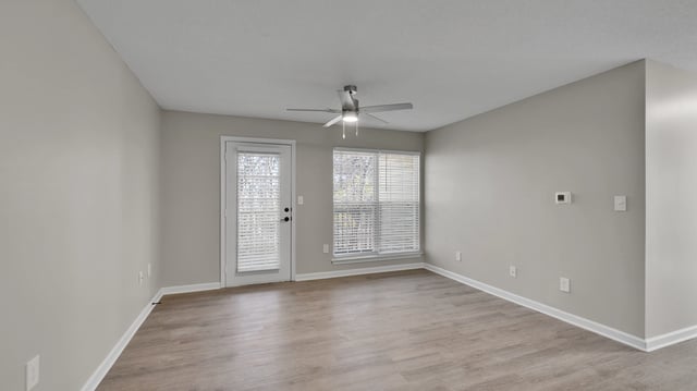 Living room with ceiling fan and access to balcony.