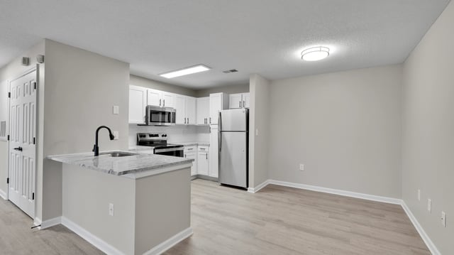 Modern kitchen with stainless steel appliances and granite countertops.