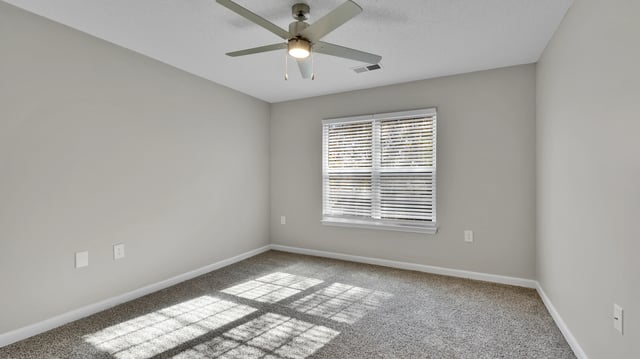Empty bedroom with a ceiling fan and blinds on the window.