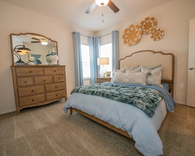 Bedroom with a king-size bed, dresser, and mirror.