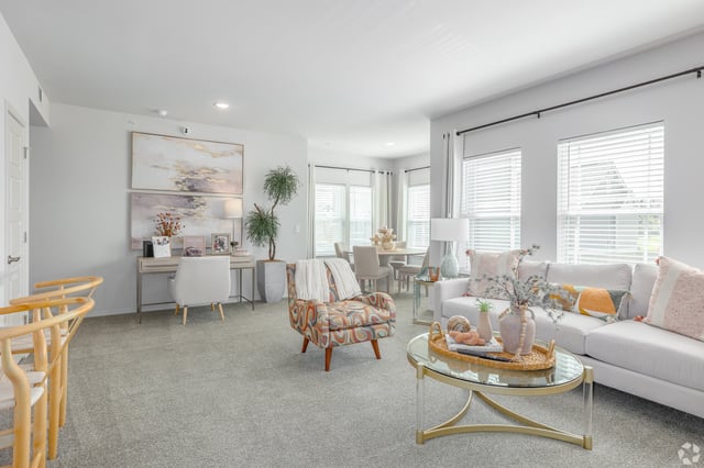 Modern living room with a sofa, armchair, coffee table, and a desk.
