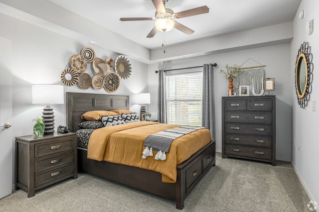 Primary bedroom with queen-size bed, bedside tables, dresser, and wall decor.
