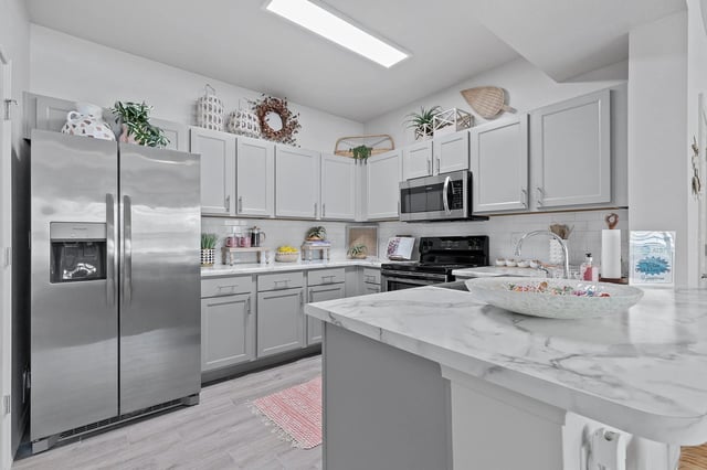 Modern kitchen with stainless steel appliances and marble countertops