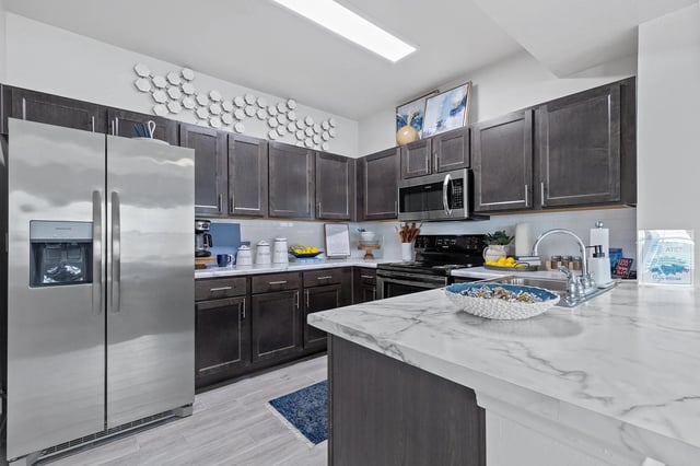 Modern kitchen with stainless steel appliances and marble countertop