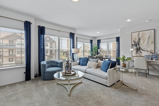 Spacious living room with a sofa, armchair, coffee table, and desk by the window.